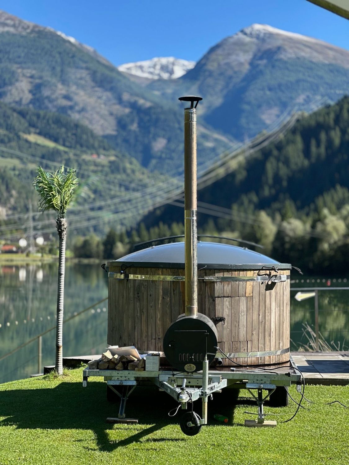 Der mobile Holz-Whirlpool von RelaxMobil am See vor den Bergen